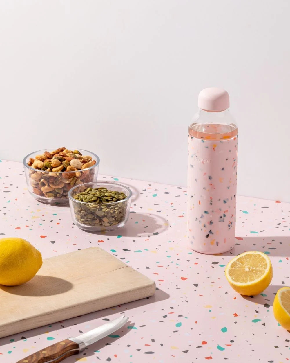 Glass reusable water bottle with terrazzo print silicone wrapped around for design and grip