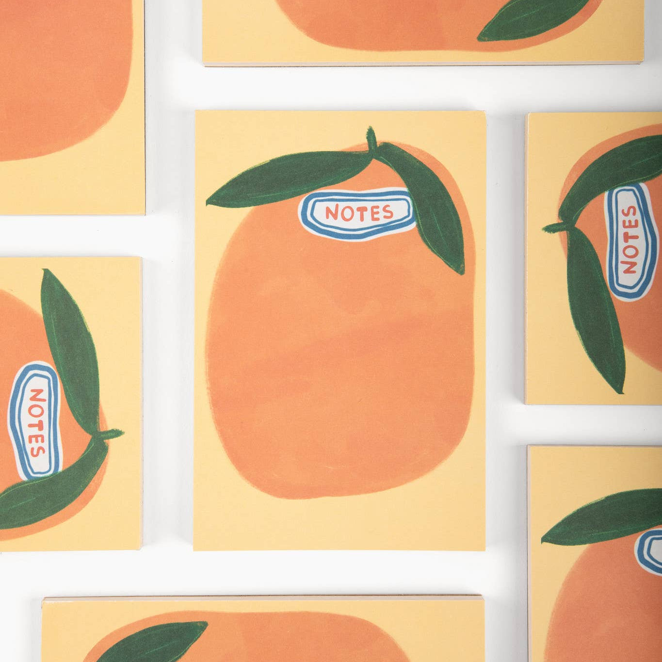 Notebooks with wonky orange design and 'NOTES' label on a white background