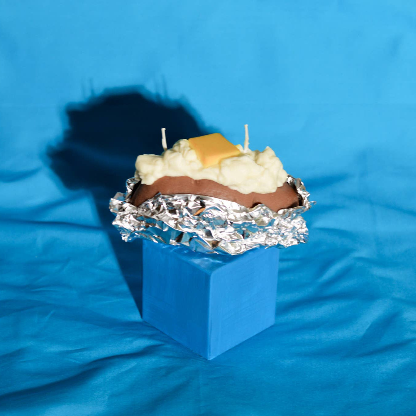 candle that looks like a baked potato with a pad of butter on top