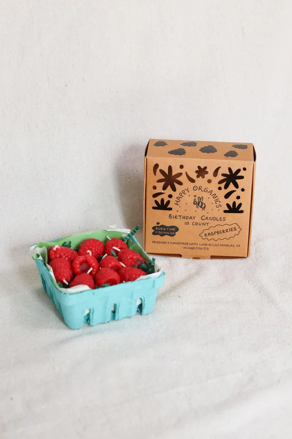 Carton of raspberry candles with a cardboard box on a light background