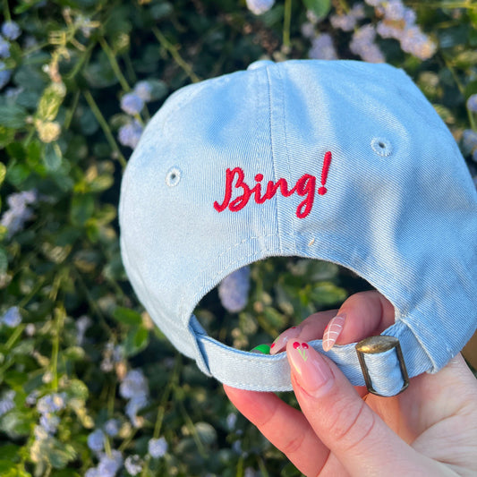 Has the text "Bing!" embroidered in red on center back of hat above adjustable strap