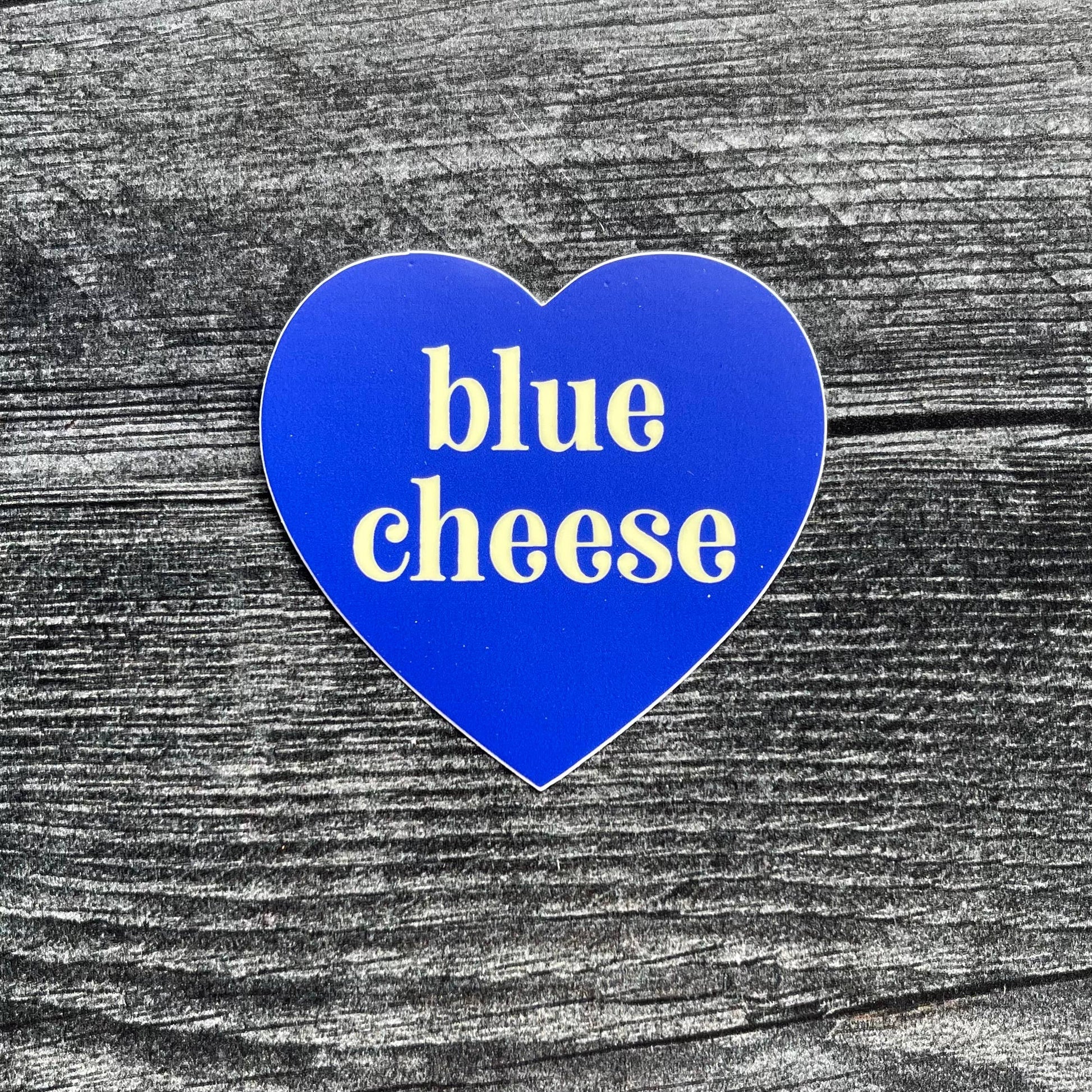 blue, heart-shaped sticker with text in center that says "blue cheese"