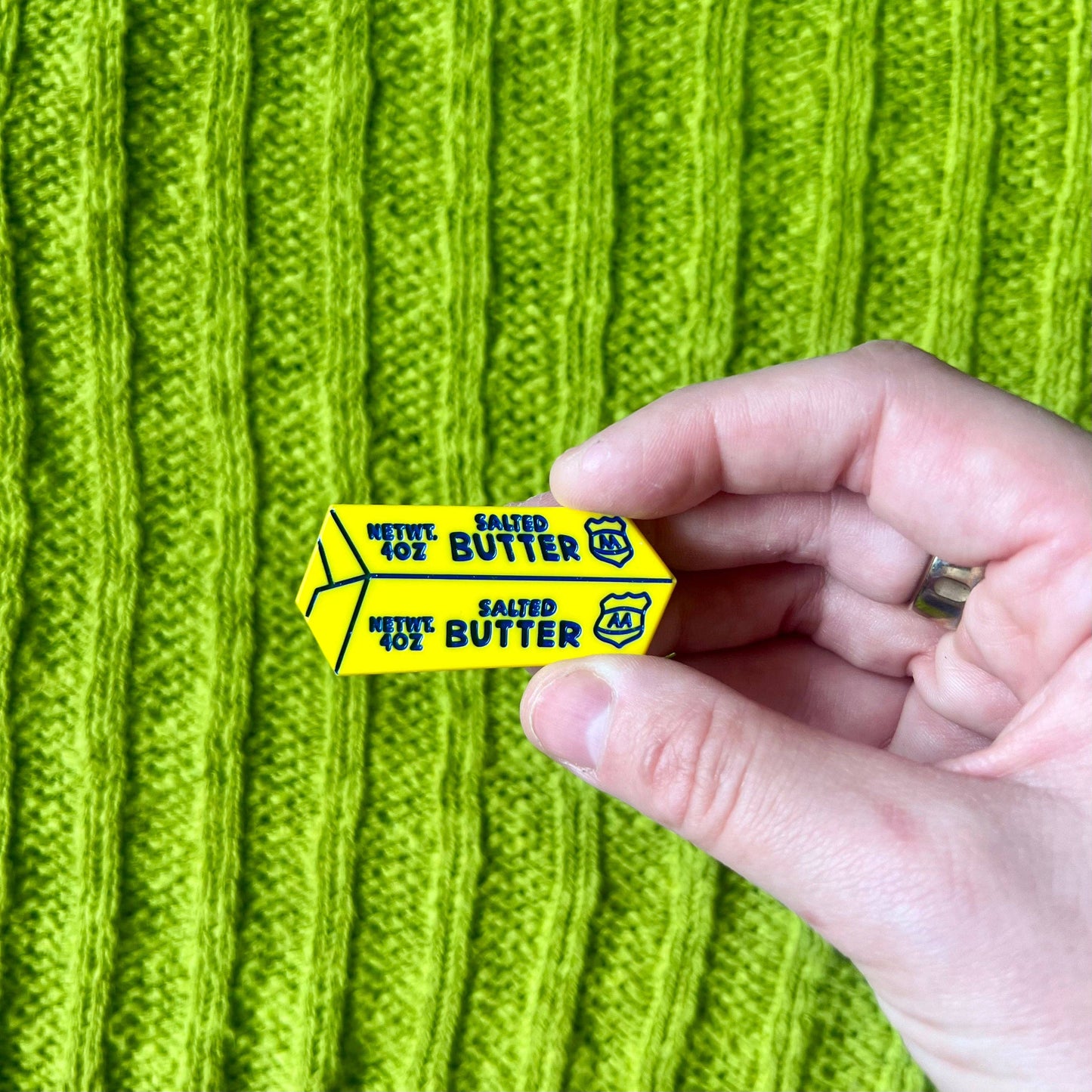 Single hair clip that looks like a stick of salted butter -- yellow with blue font