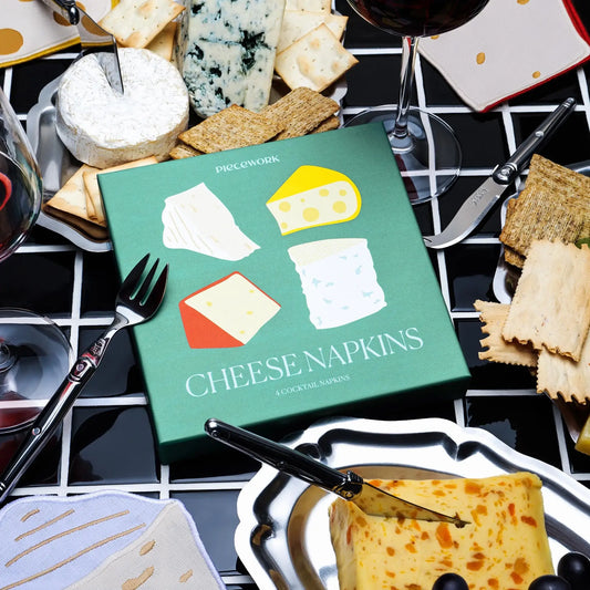 Cheese cloth cocktail napkins packaging pictured with cheese and wine on a checkered tablecloth