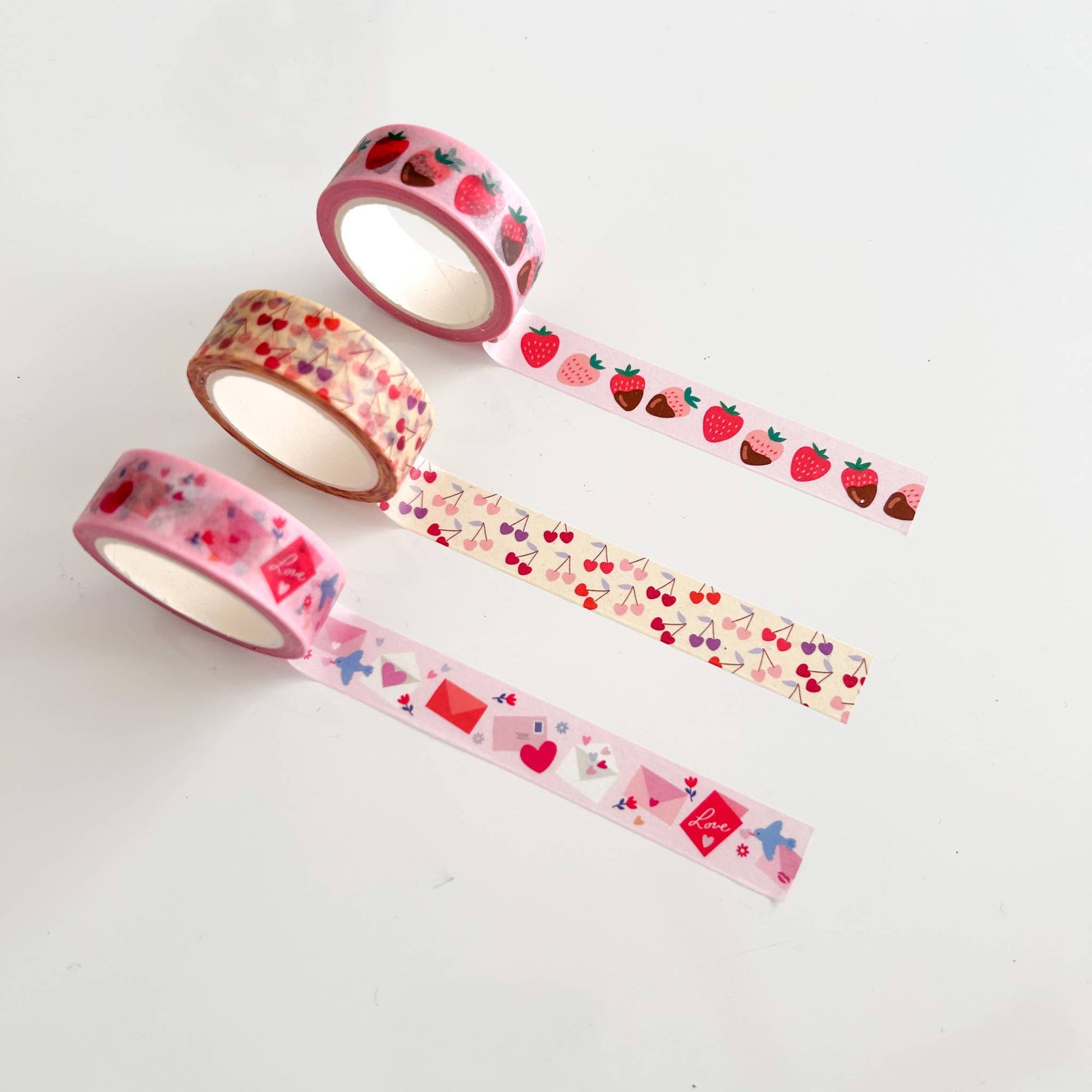 3 washi tapes pulled out to showcase the design -- red and pink envelopes, heart shaped cherries and chocolate covered strawberries
