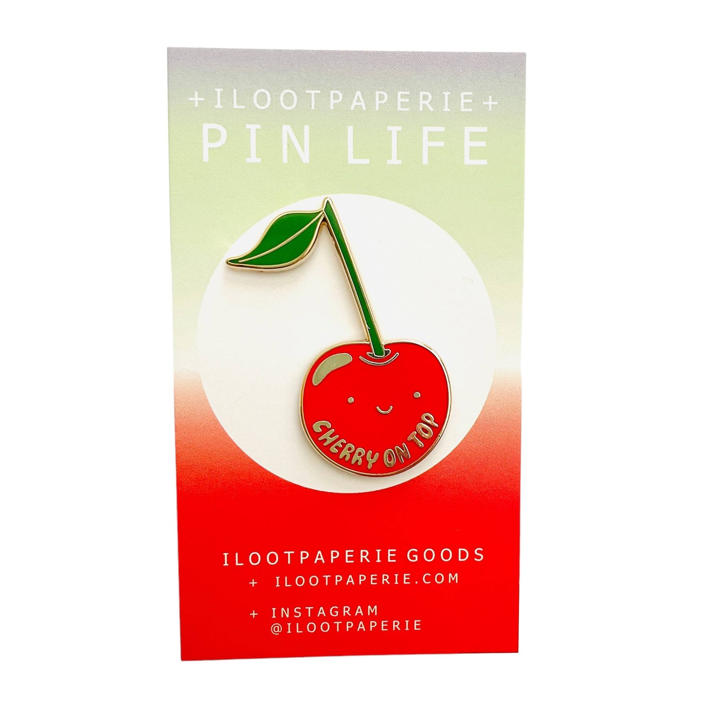 Cherry-themed enamel pin on a colorful card with 'ILOOTPAPERIE' branding.