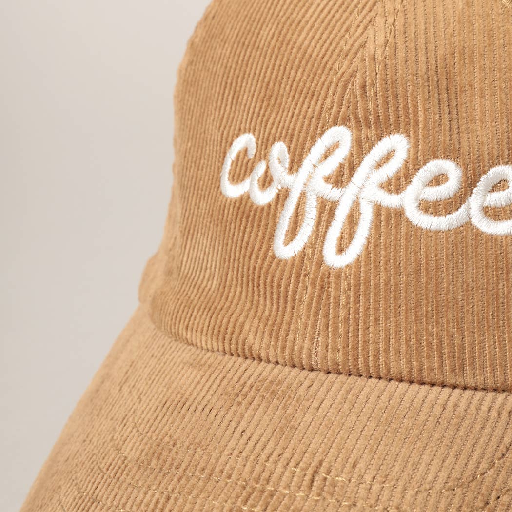 zoomed in view of embroidery on front of hat. Text says "coffee"
