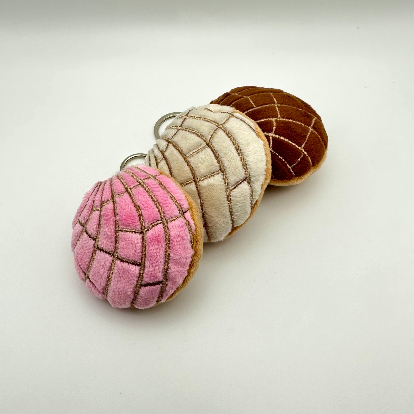 all 3 concha keychains in pink, white and brown