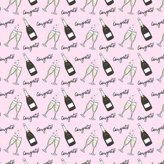 roll of wrapping paper that has a pink background with a continuous pattern of a champagne bottle, two flutes clinking and the text "congrats" all over