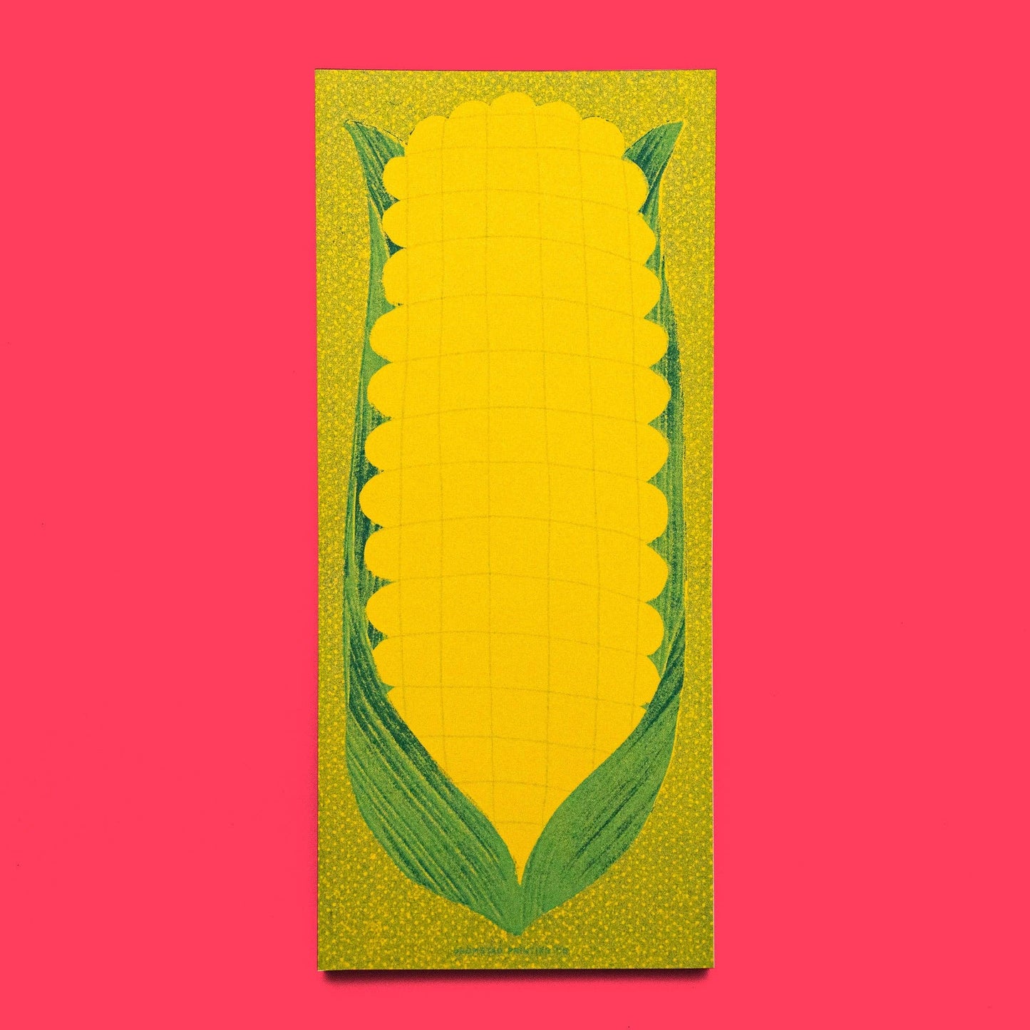 green and yellow notepad, designed with a risograph print of an ear of corn with husk on it