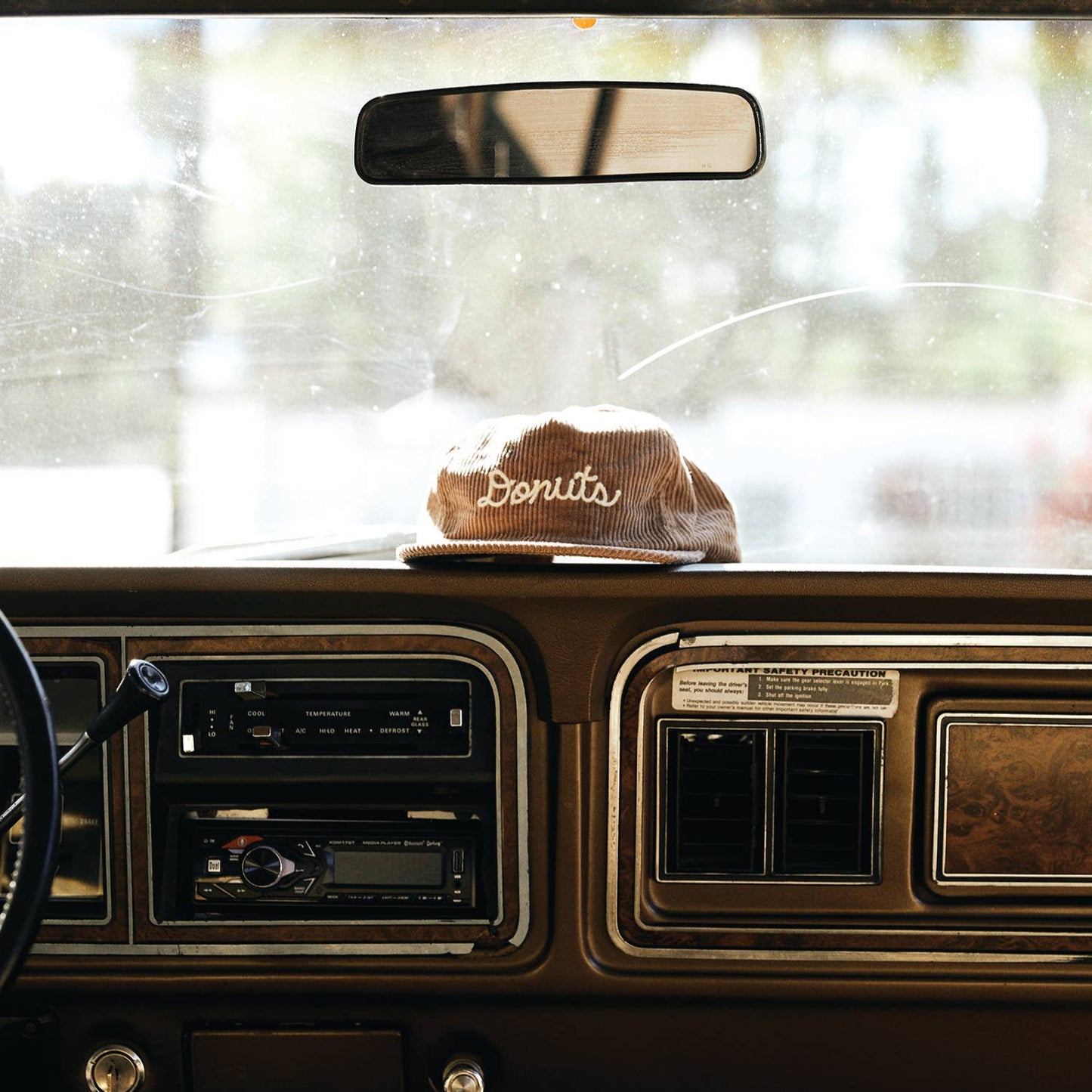 corduroy hat with chainstitched text that reads "Donuts"