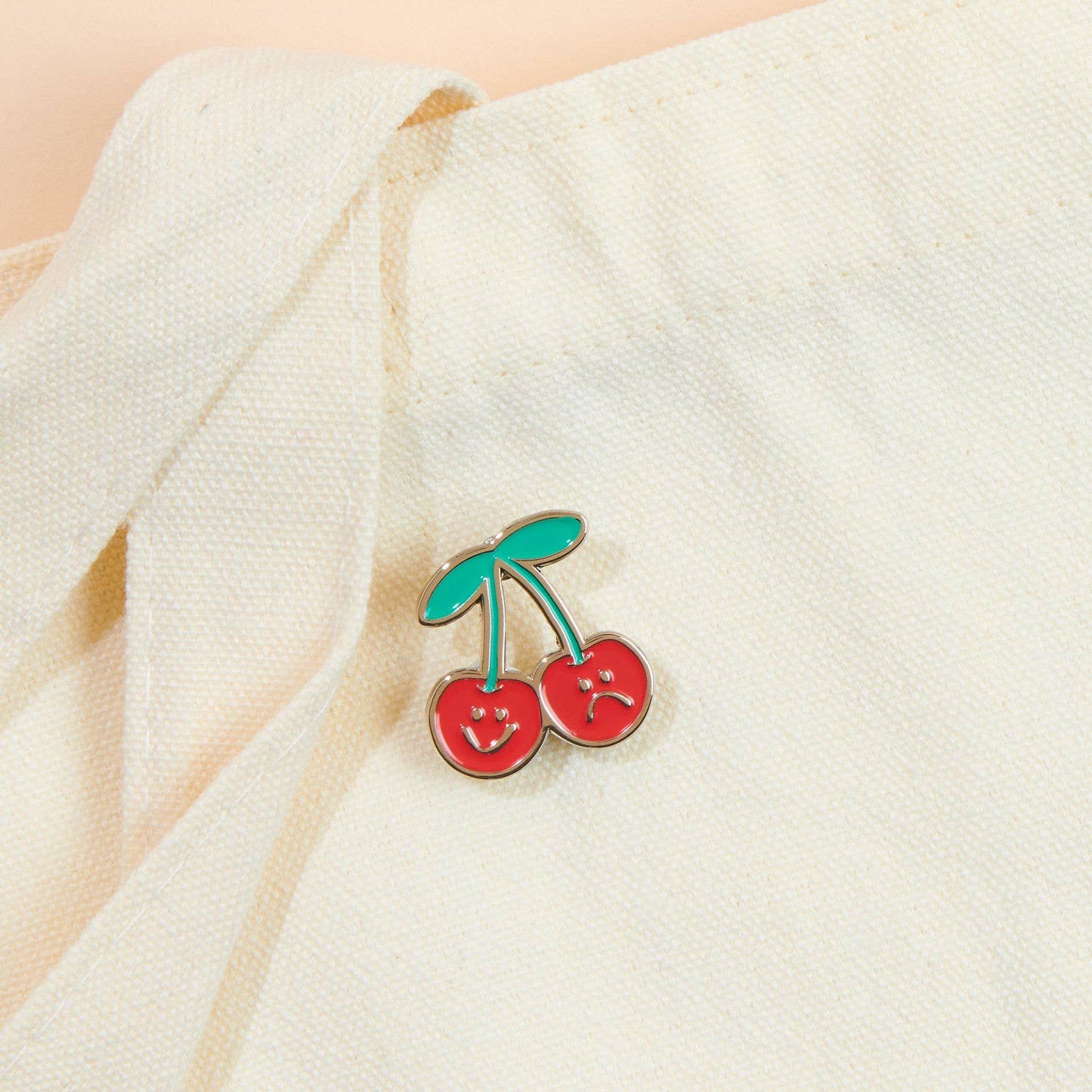Duo of cherries one with a smiley face and the other with a sad face