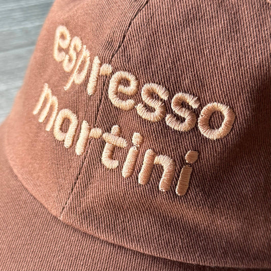 Brown cap with 'espresso martini' embroidery on a blurred background