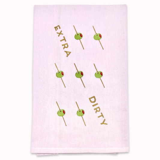 White kitchen towel with olive skewer design and text "extra dirty" on a white background