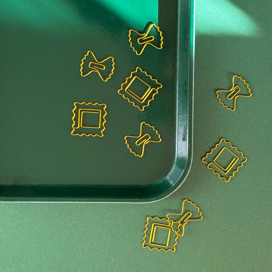 Paper clips shaped like farfalle and ravioli pasta