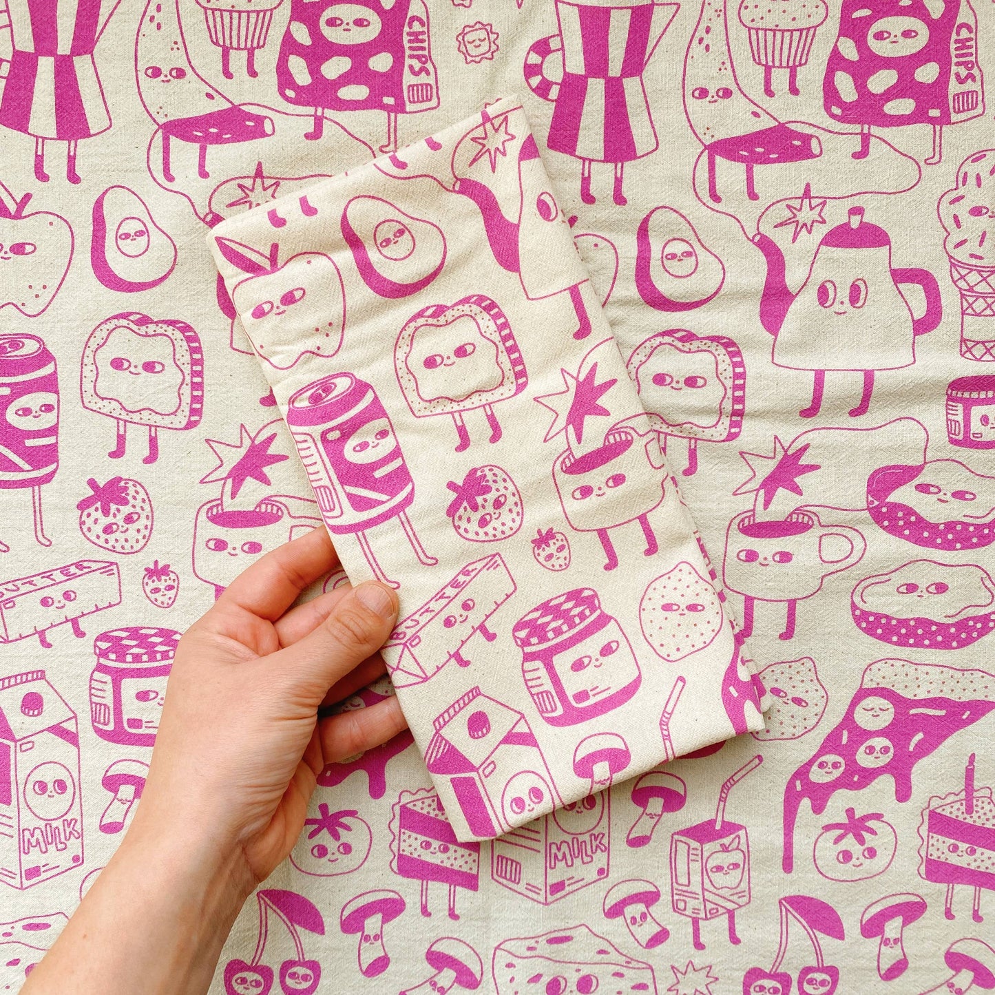 tea towel with various foods/snacks/drinks printed with magenta ink