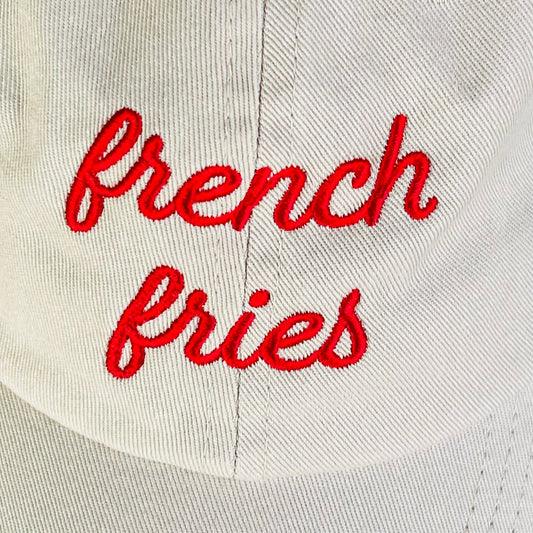 Beige cap with red 'French Fries' text close up view