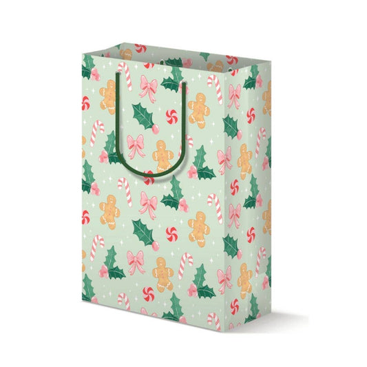 Gift bag with Christmas-themed pattern, featuring gingerbread, candy canes, holly and bows, on a white background