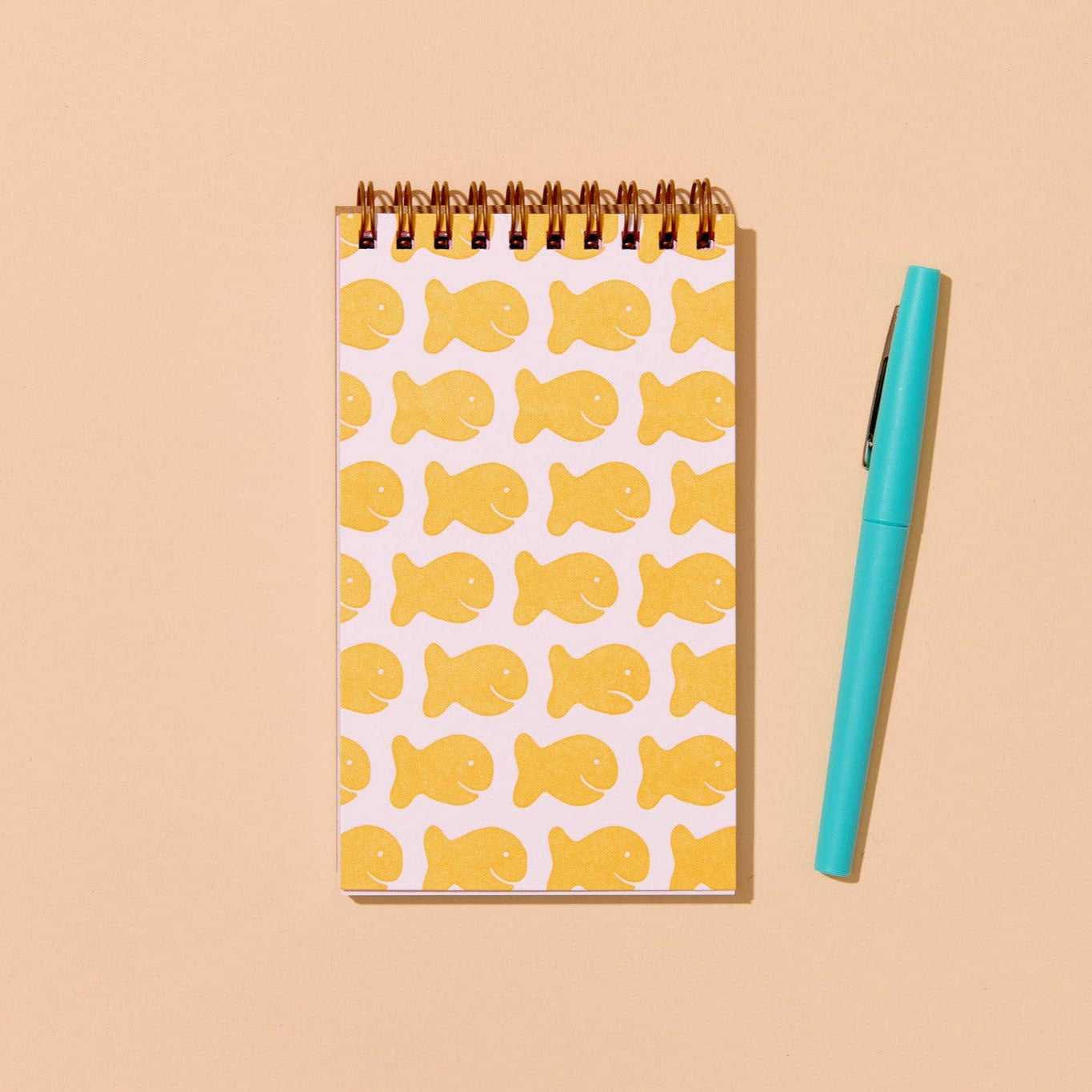 goldfish pocket notebook with pen placed next to it for sizing