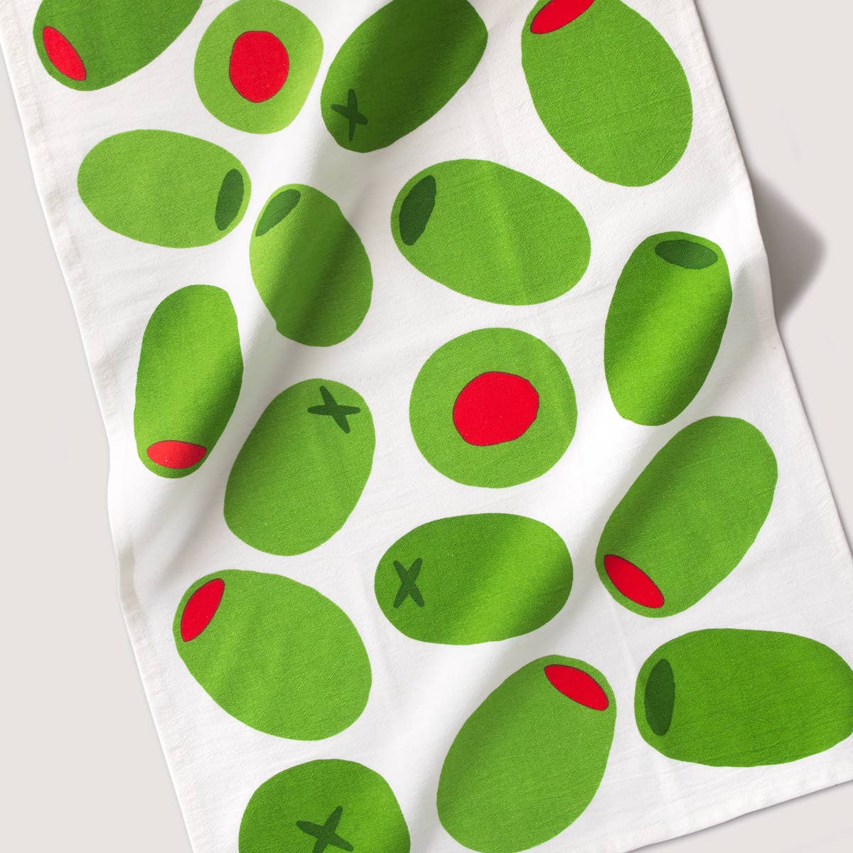 Tea towel with green olives pattern on a white background