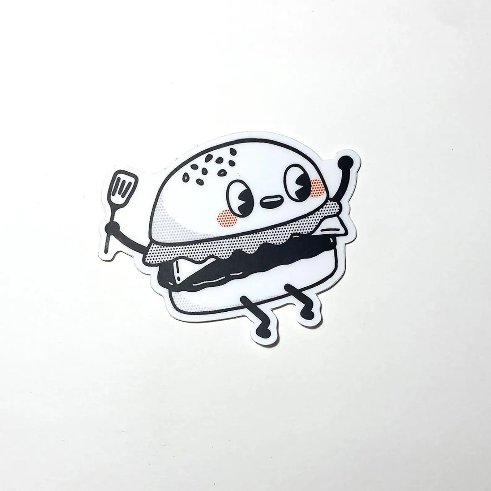 Cartoon burger character holding a spatula on a white background