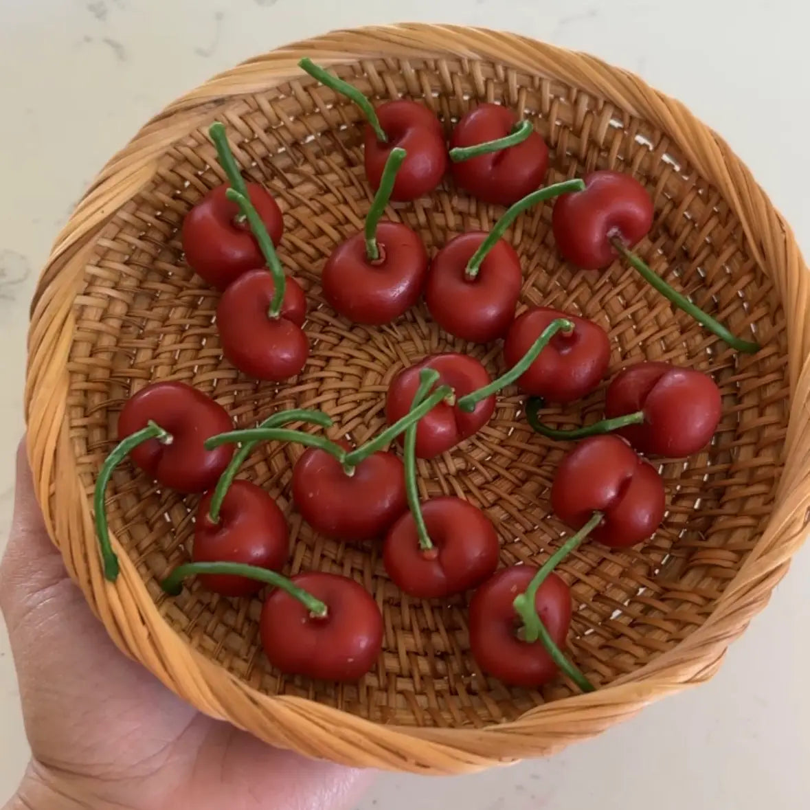 17 Realistic cherry candles in a wicker basket.