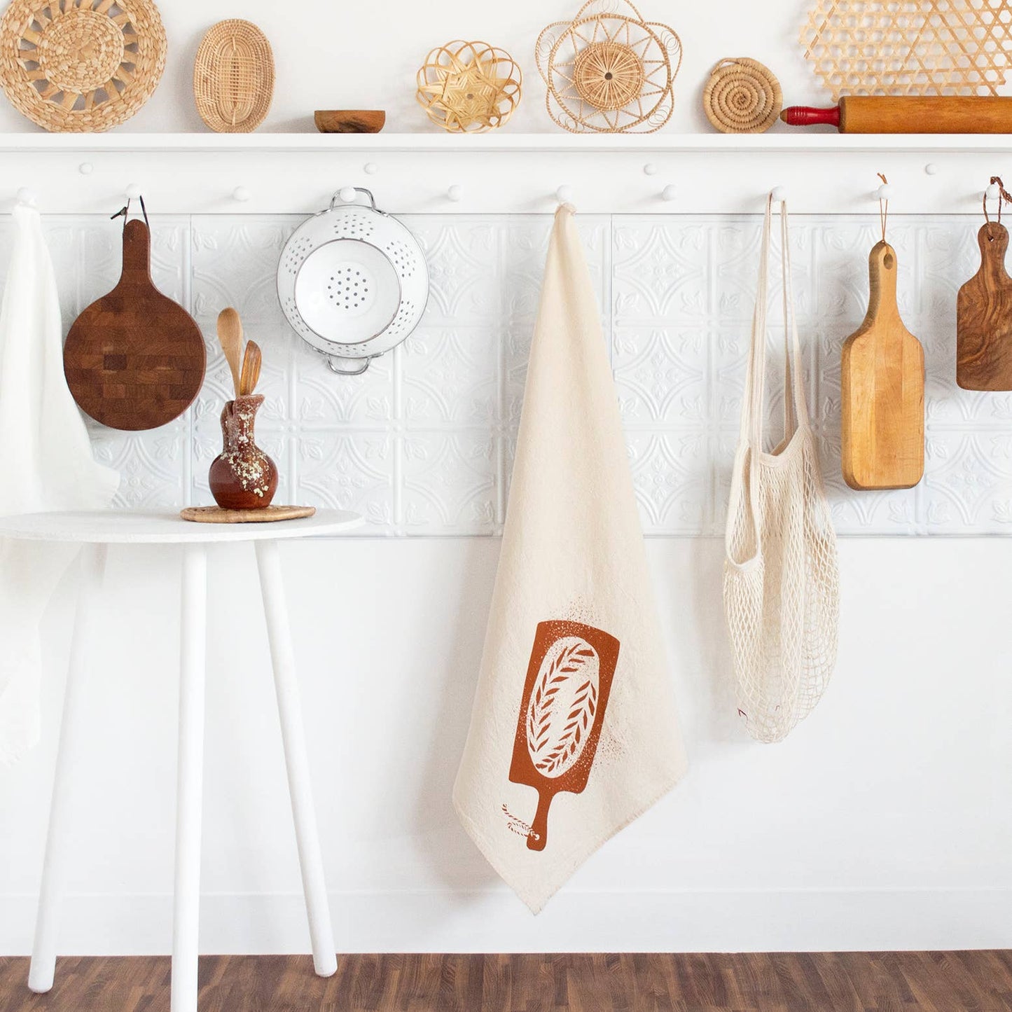 kitchen towel designed with a loaf of bread on a bread board hanging on a peg