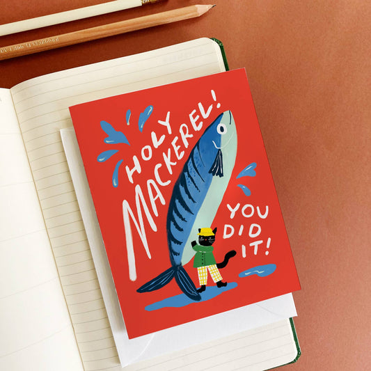 Greeting card with fish illustration and text on a notebook with pencils and a sharpener.