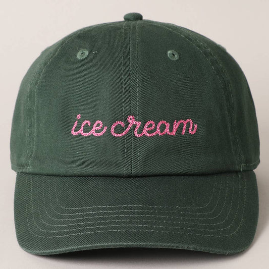 Green cap with 'ice cream' embroidered in pink on a beige background