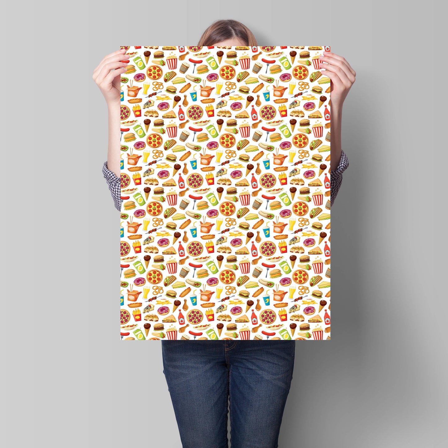 Person holding a sheet of wrapping paper with food patterns against a gray background