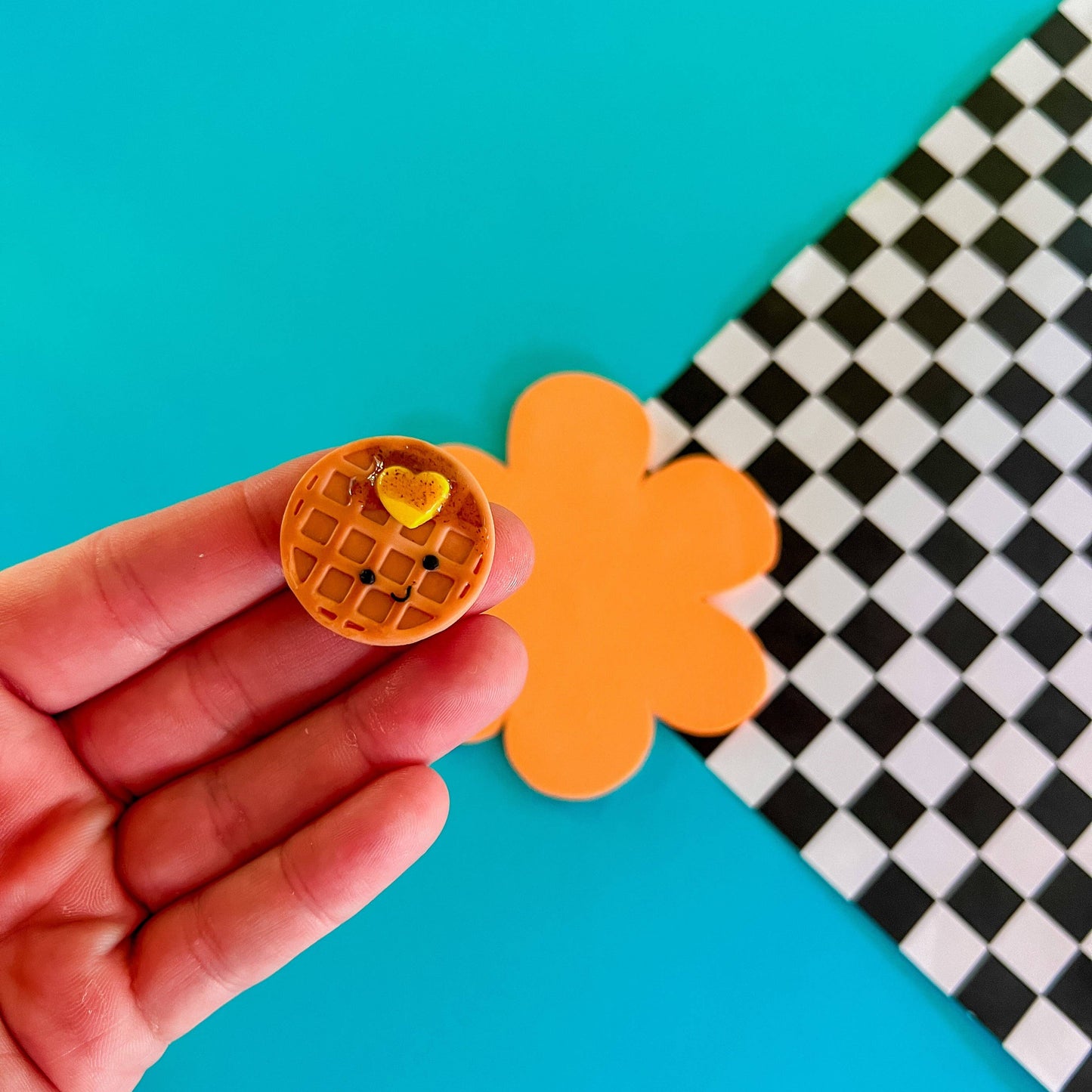 mini smiley faced waffle magnet with a heart-shaped pad of butter and syrup on it