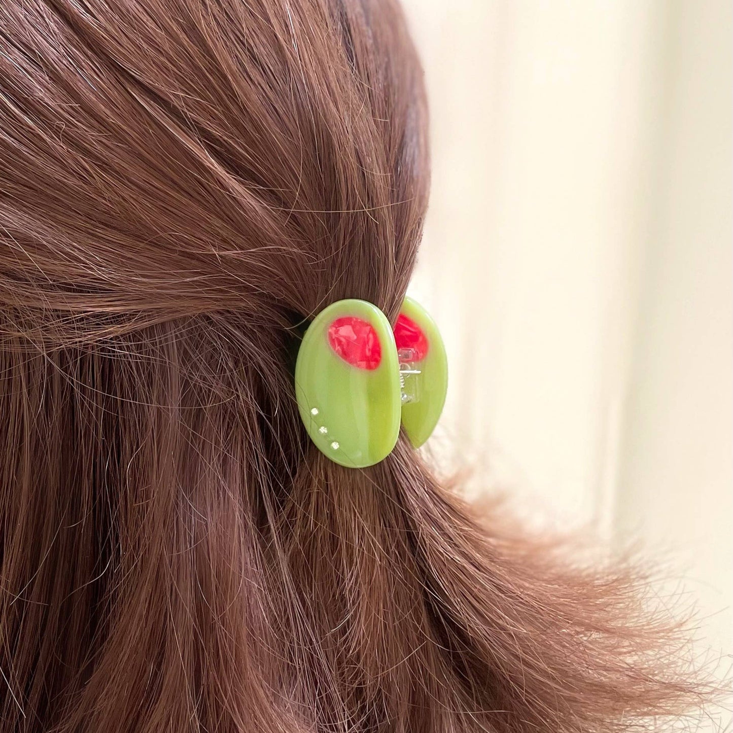 mini olive hair claw holding hair