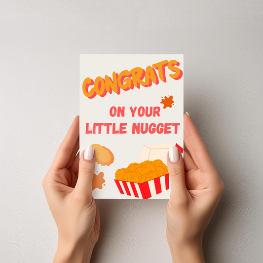 Card with 'Congrats on your little nugget' text held by hands against a gray background
