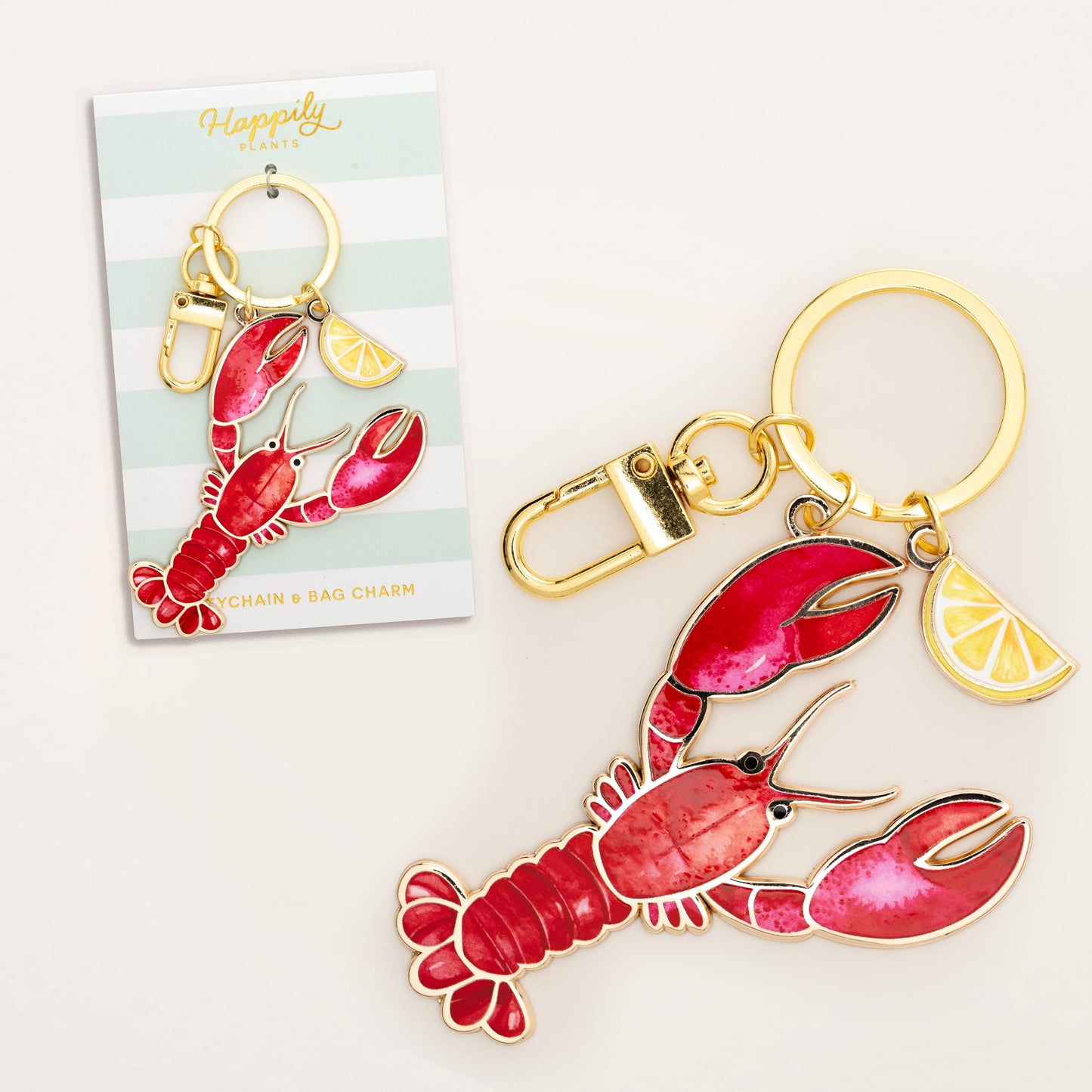 Lobster with lemon wedge keychain with gold accents on a white background