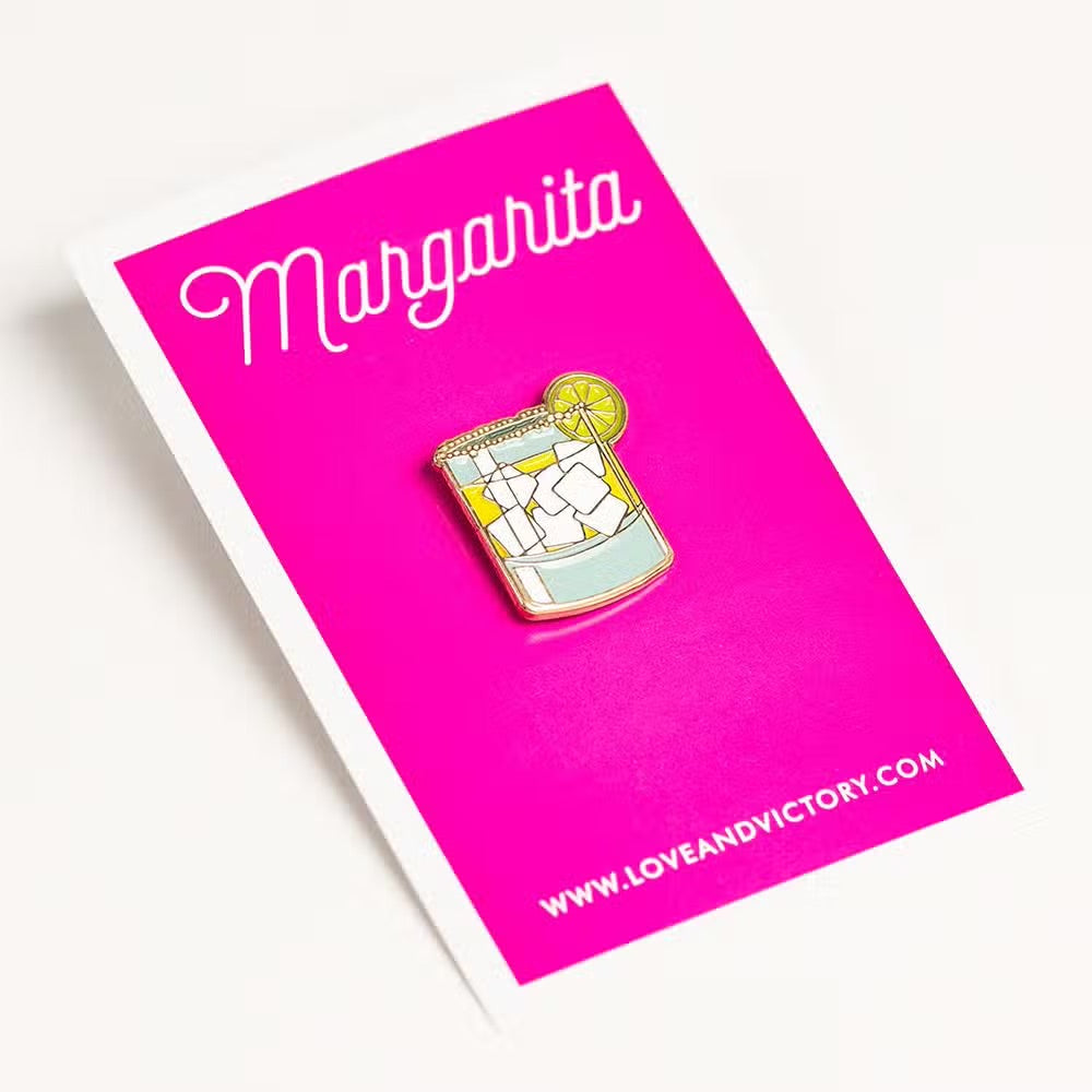 Margarita lapel pin on pink card backing.