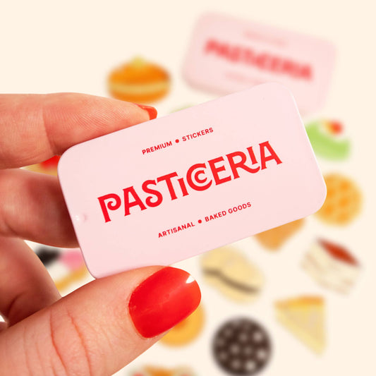 light pink tin box with text in red. Reads, "Premium. Stickers. Pasticeria. Artisanal. Baked Goods."