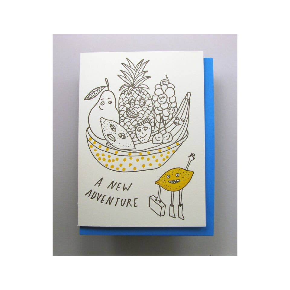 Greeting card with various fruits in a basket and a lemon holding a suitcase. Text reads "A new adventure"