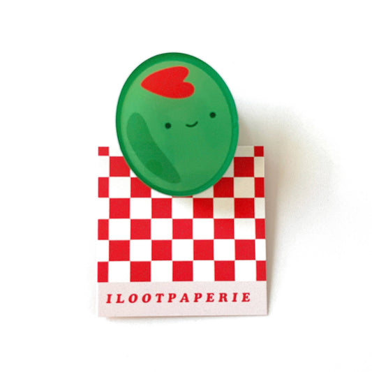 Green olive character with a red heart  as the pimento stuffing on a checkered box labeled 'ILOOTPAPERIE' on a white background