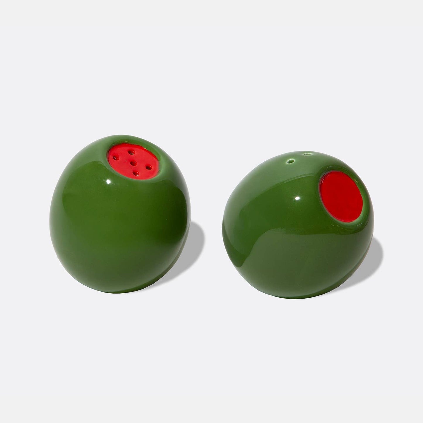 Two stuffed green olive shaped salt and pepper shakers on a white background