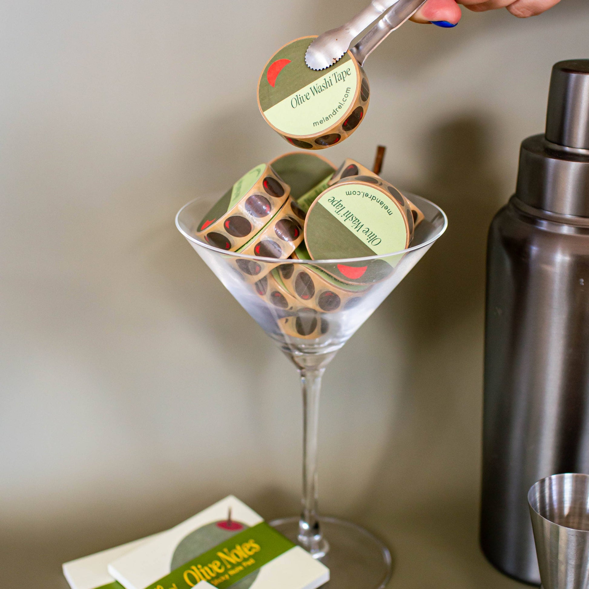 pictured here are several olive washi tapes in a martini glass and the original olive sticky notes at the bottom
