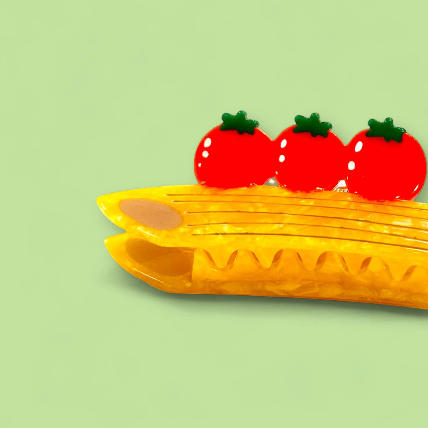 hair claw shaped like a penne pasta with 3 tomatoes on top