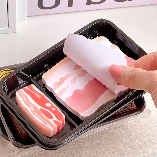 hand flipping through a memo pad that looks like sliced pork belly