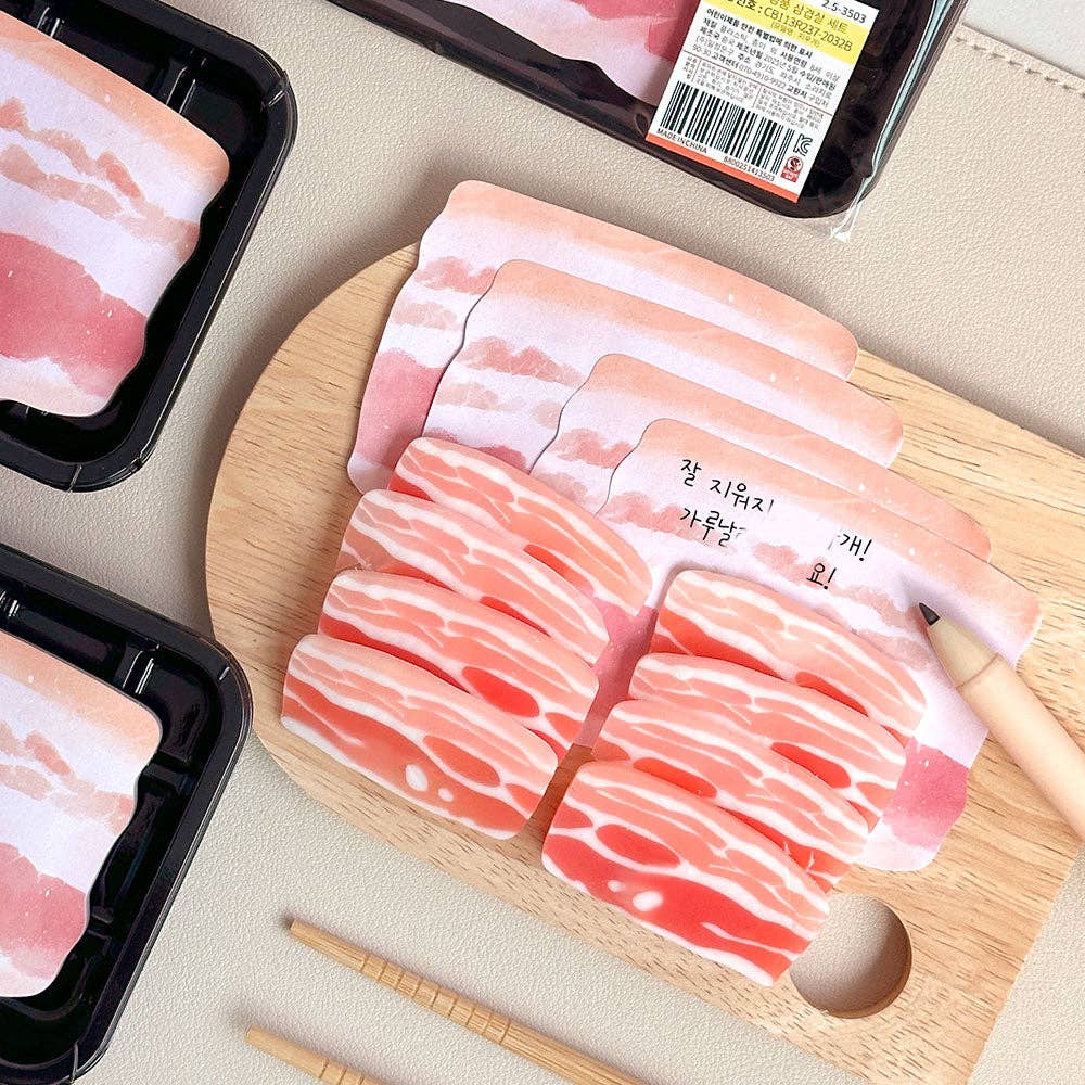 Eraser and memo notes that look like sliced pork belly on a table with chopsticks and a cutting board.