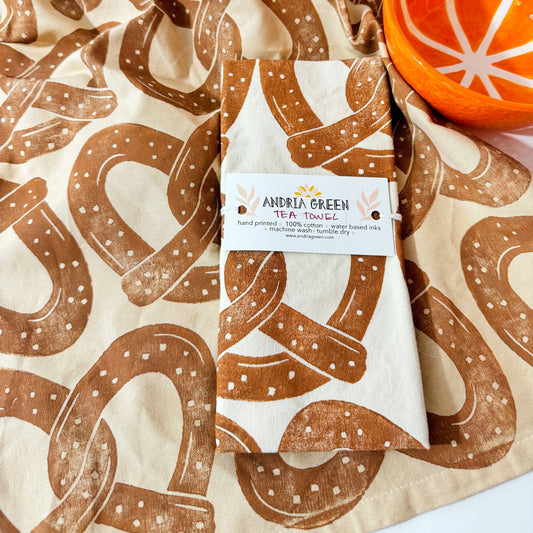 kitchen towel designed with a repeated patter of soft, salted pretzels