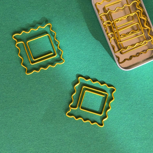 Set of 5 paper clips shaped like ravioli pasta. Comes in small tin storage box