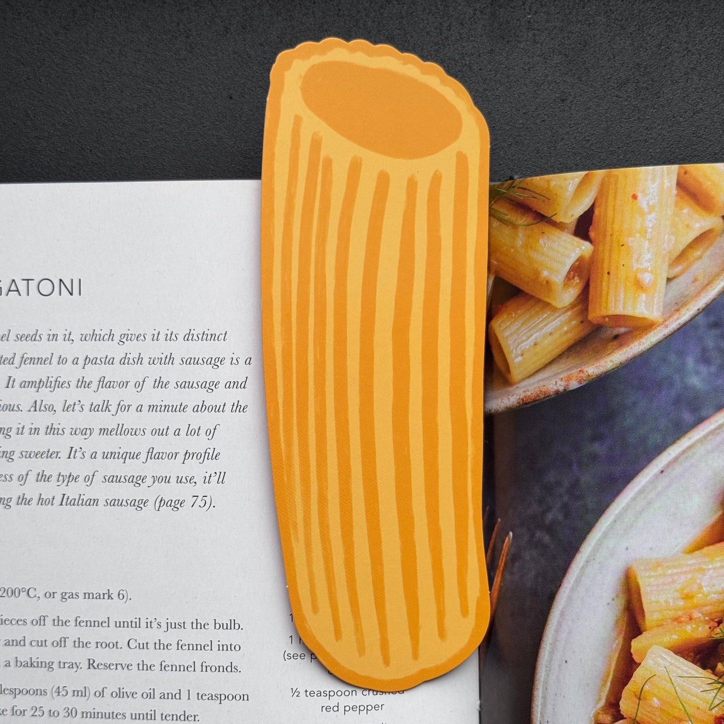 Pasta-shaped bookmark on a magazine with pasta images in the background