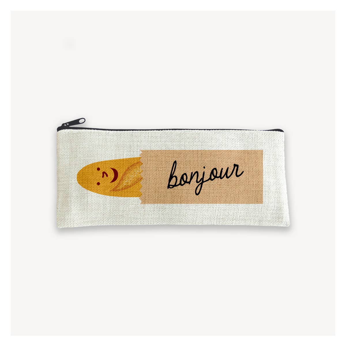 canvas pencil pouch with a smiley faced baguette in a brown paper bag with text on it that reads "bonjour"