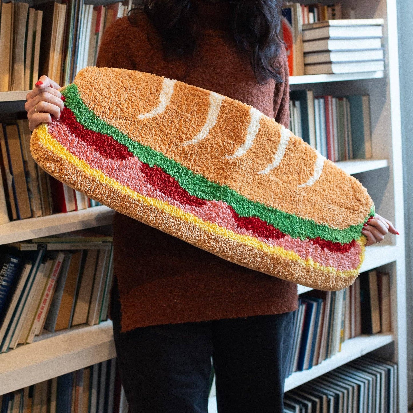 sandwich shaped rug being held by a person