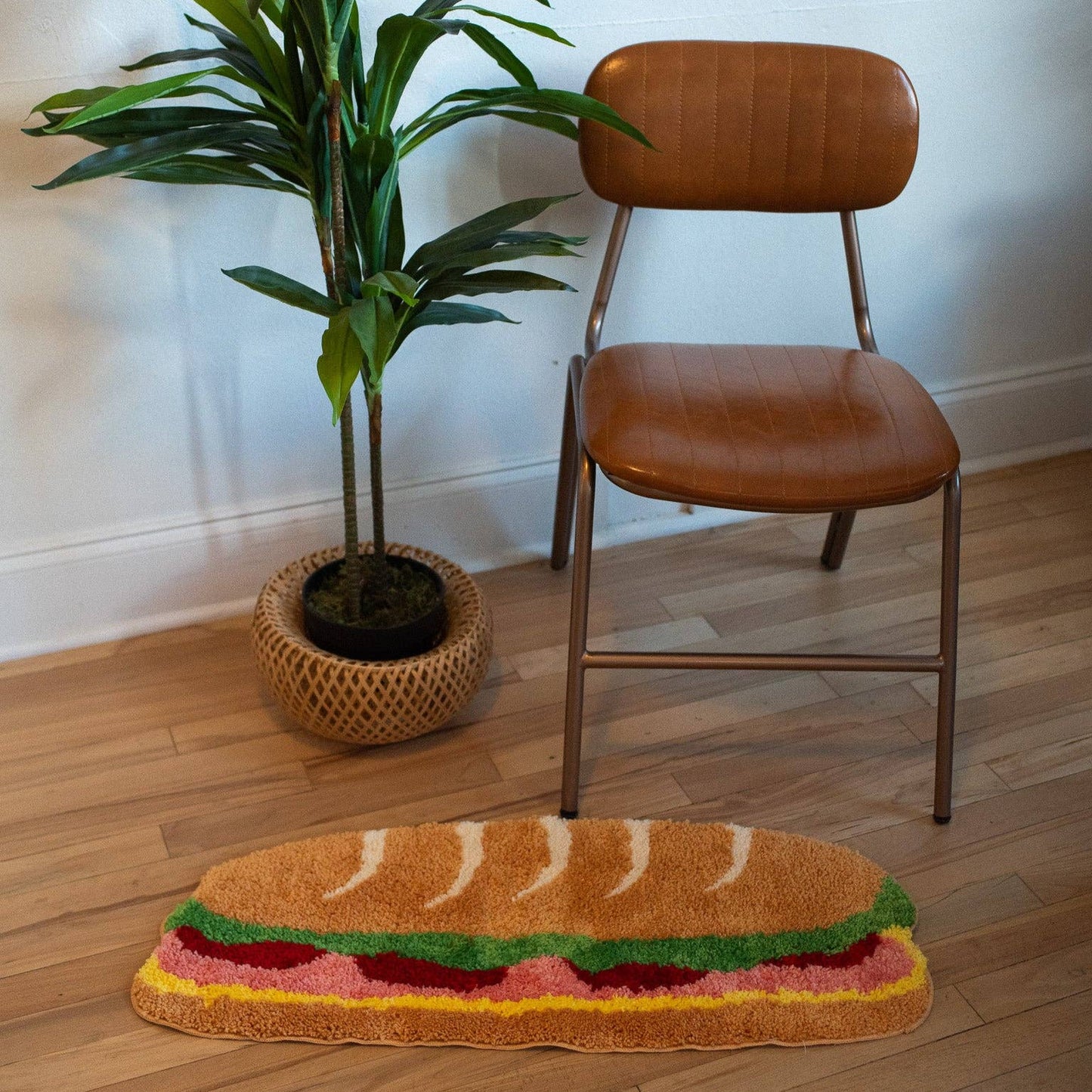 sub sandwich shaped rug photographed on floor in front of a plant and chair