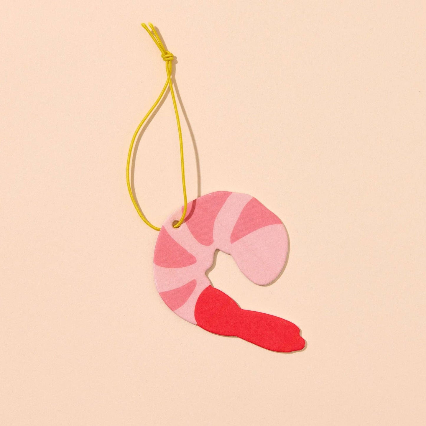 shrimp shaped air freshener on yellow string on light background